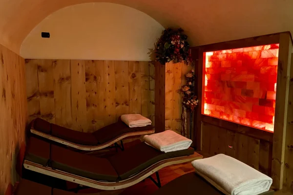 Stanza relax con lettini e pannello di sale illuminato.